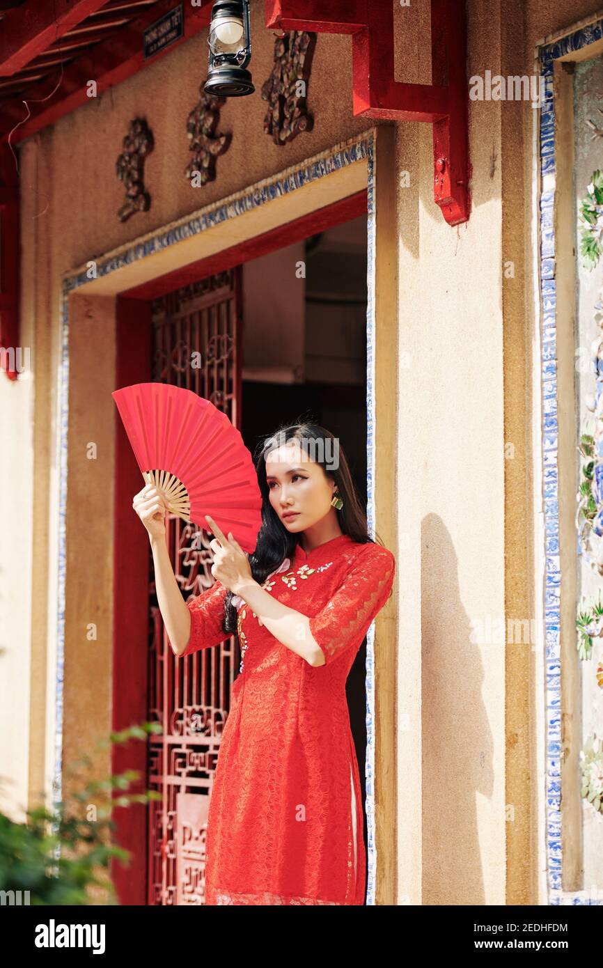 Femme asiatique posant avec un fan de papier Banque D'Images