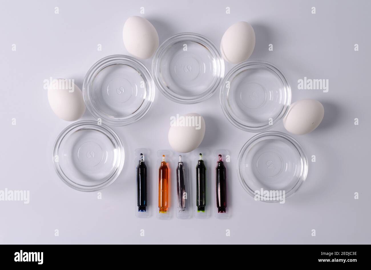 Préparation pour Pâques, le concept de coloriage des oeufs, les matières pour colorier les oeufs - oeufs blancs, teintures, bols avec liquide. Étape 2 Banque D'Images