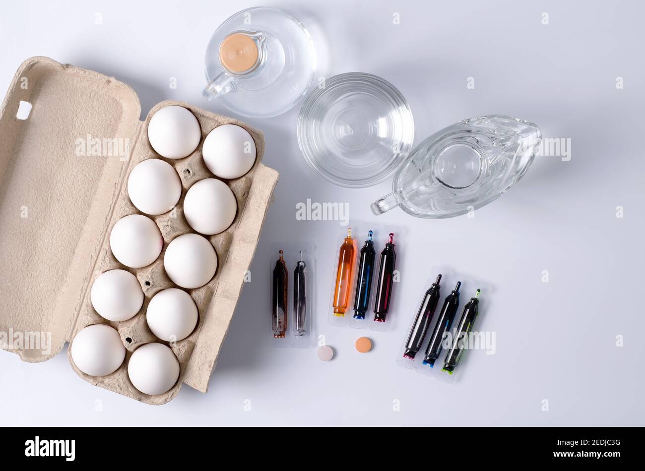 Préparations pour Pâques, le concept de coloriage des oeufs, les matériaux de coloriage se trouvent sur un fond clair - oeufs dans une boîte, teintures, ustensiles avec de l'eau et Banque D'Images