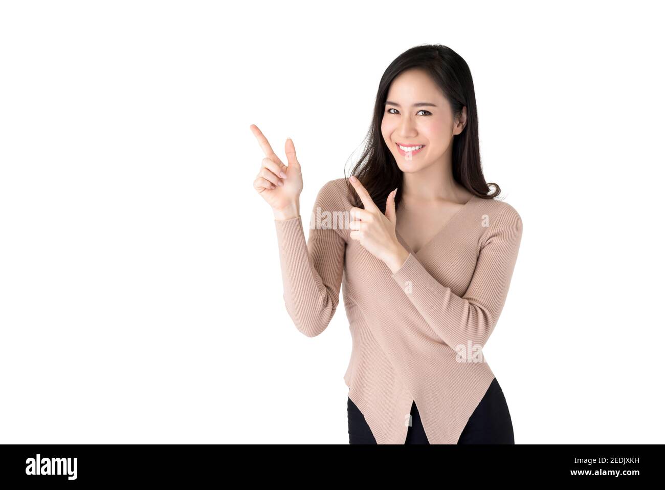 Belle jeune femme asiatique décontractée souriant et pointant les mains vers l'espace vide de côté, studio tourné isolé sur fond blanc Banque D'Images