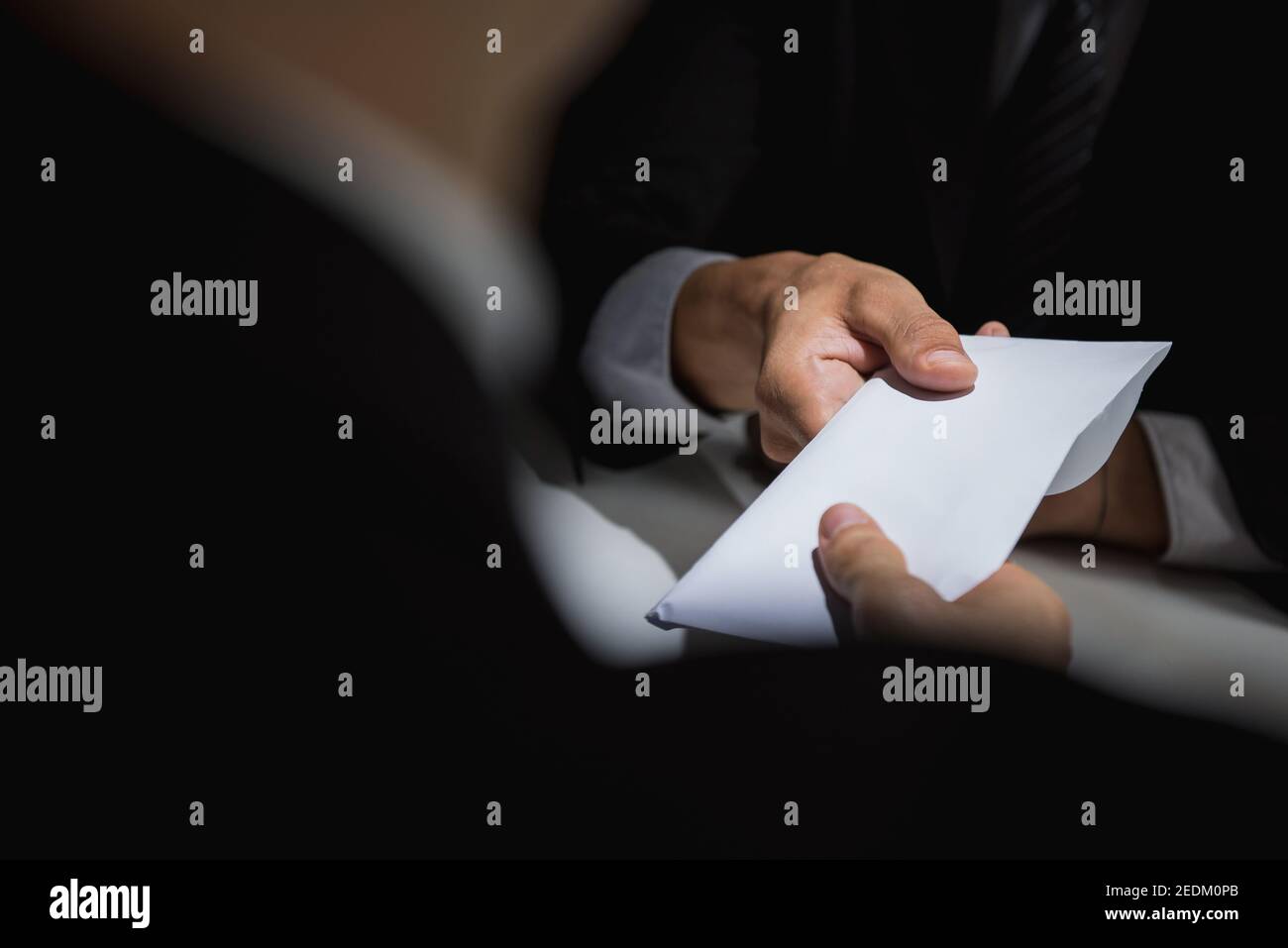 Homme d'affaires donnant de l'argent de pot-de-vin dans une enveloppe blanche à son partenaire une escroquerie à la corruption Banque D'Images