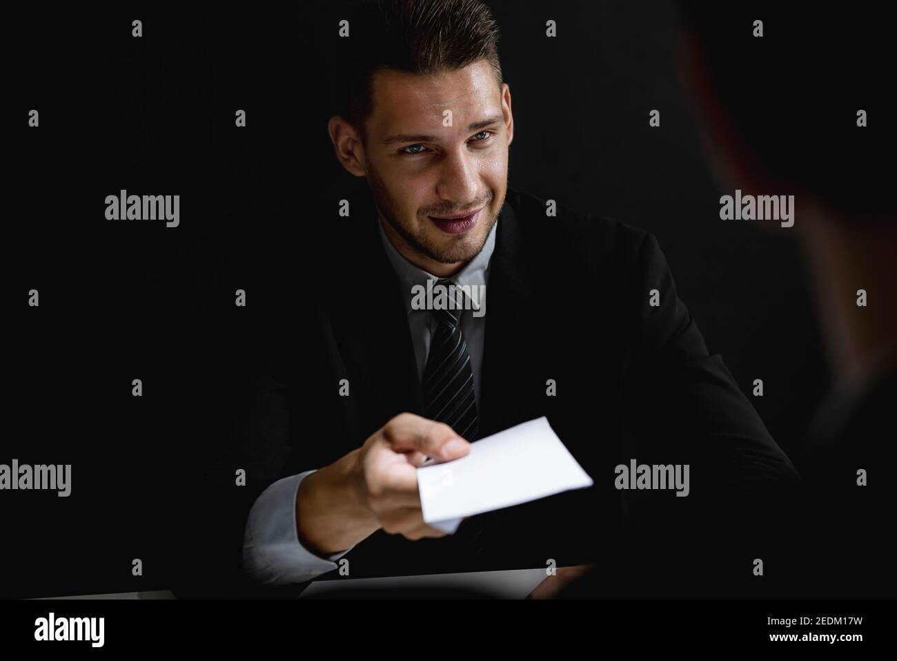 Homme d'affaires offrant de l'argent de pot-de-vin dans l'enveloppe blanche à partenaire dedans une escroquerie à la corruption Banque D'Images