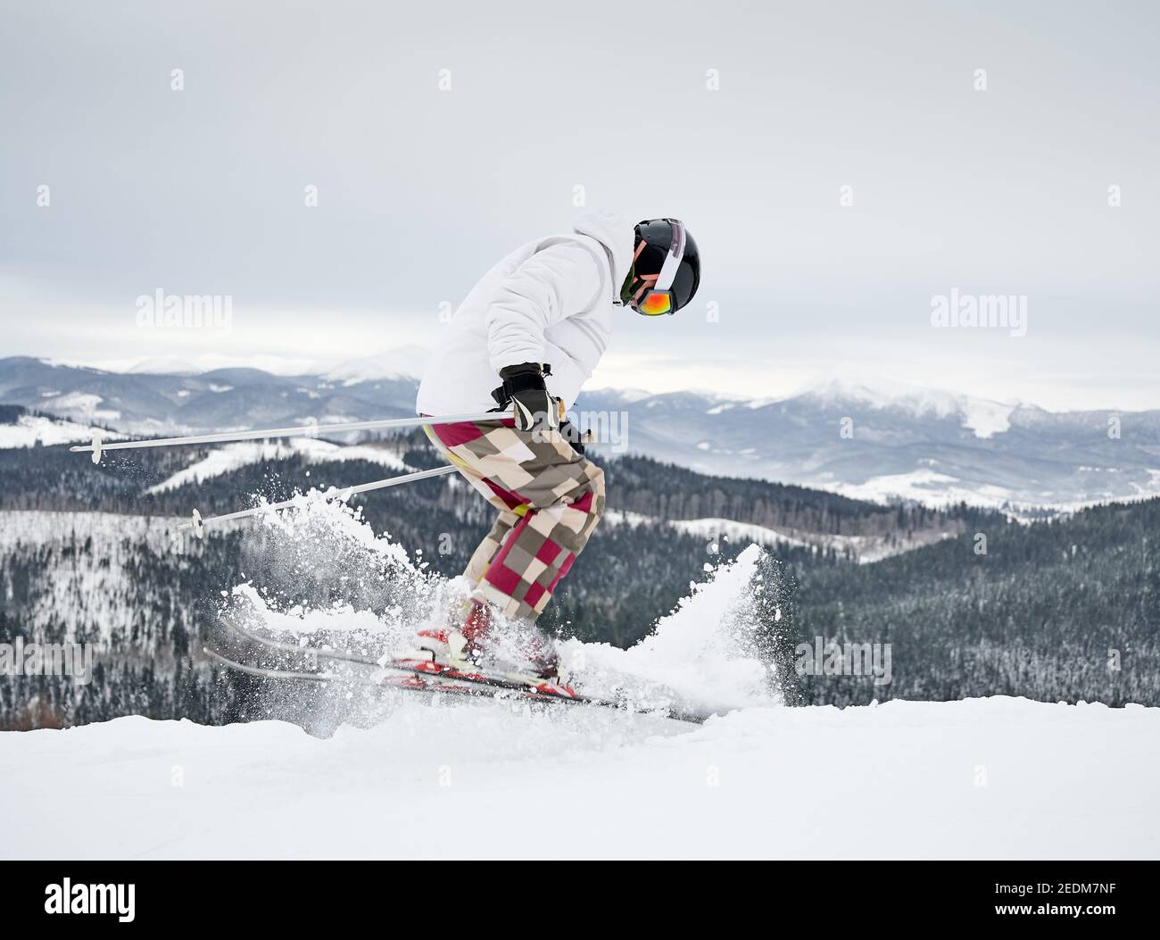 Ski alpin sur toute la longueur sur la neige poudreuse fraîche dans les  montagnes d'hiver. Homme freerider dans le pantalon de ski d'hiver faisant  sauter tout en glissant sur les pistes enneigées.