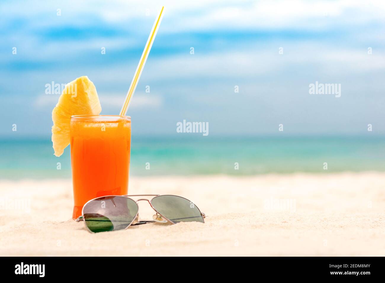 Boisson fraîche aux fruits tropicaux avec lunettes de soleil en été fond de plage de sable blanc avec espace de copie Banque D'Images