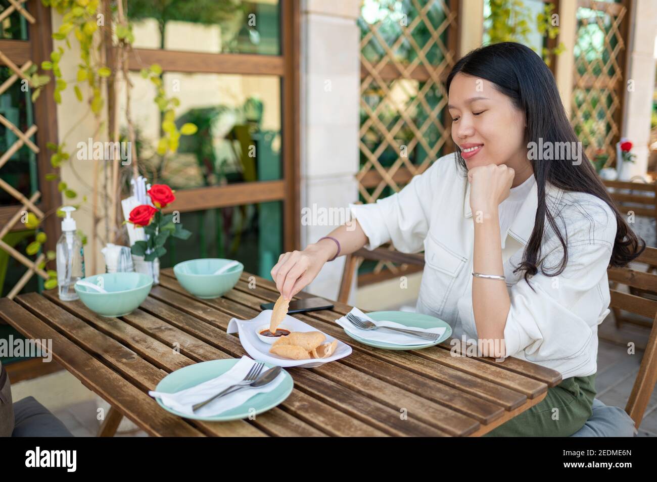 Femme asiatique ayant des craquelins de crevettes thaïlandais hors-d'œuvre avant le repas Le restaurant thaïlandais Banque D'Images