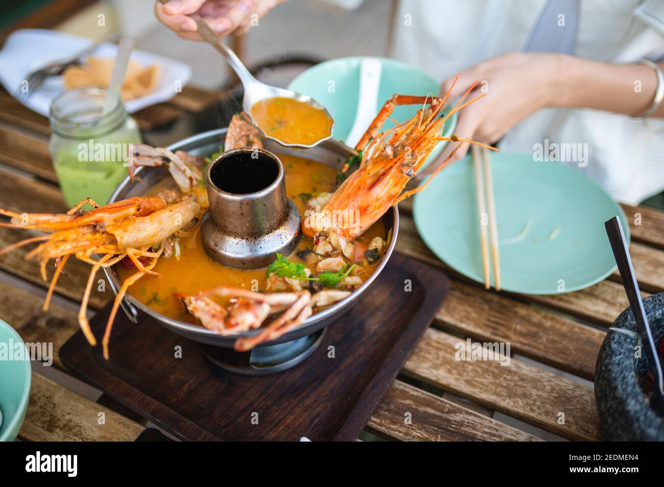 Femme ayant la soupe thaï Tom Yum avec des crevettes et du crabe dans un restaurant Banque D'Images