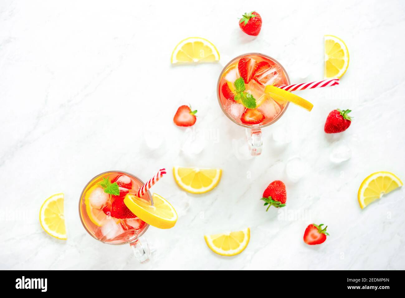 Boissons rafraîchissantes colorées pour l'été, jus de limonade froid aux fraises dans les verres avec glaçons, vue du dessus sur fond de comptoir en marbre Banque D'Images