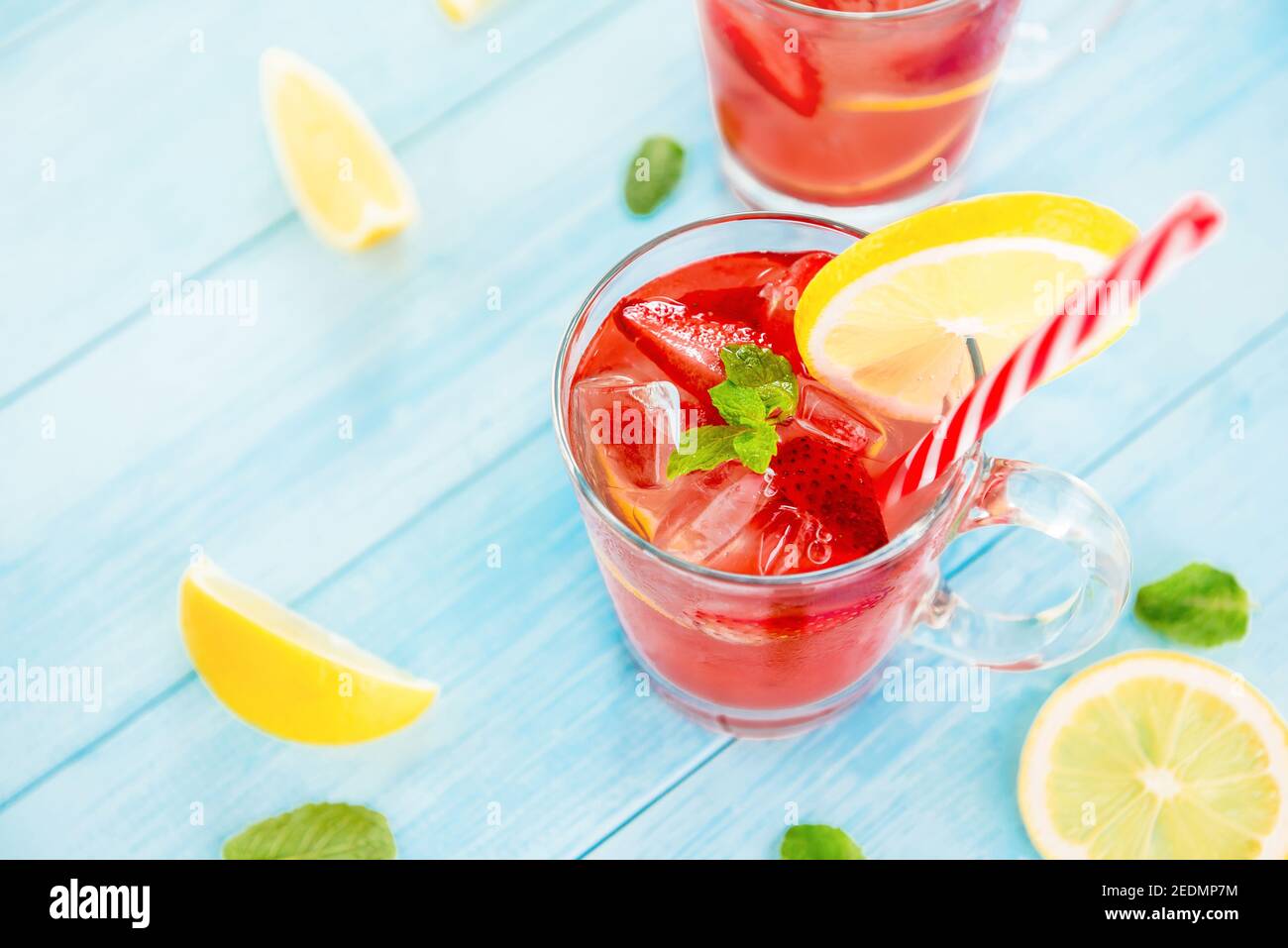 Boissons rafraîchissantes colorées pour l'été, jus de limonade froid aux fraises avec glaçons dans les verres garnis de tranches de citrons frais Banque D'Images
