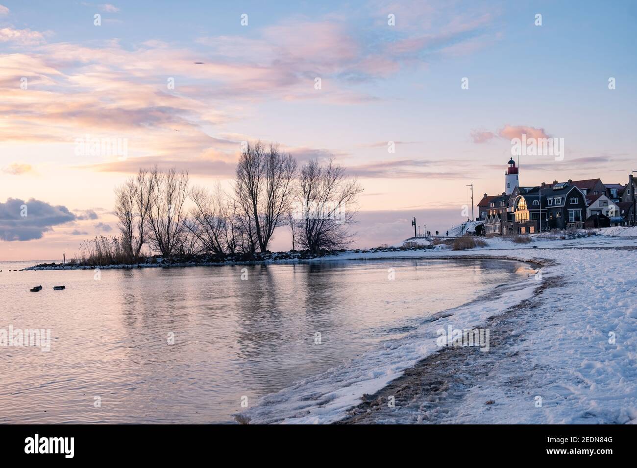 Hiver à Urk avec la digue et la plage au phare d'Urk neige couverte pendant l'hiver, coucher de soleil au phare d'Urk Flevoland. Pays-Bas Banque D'Images
