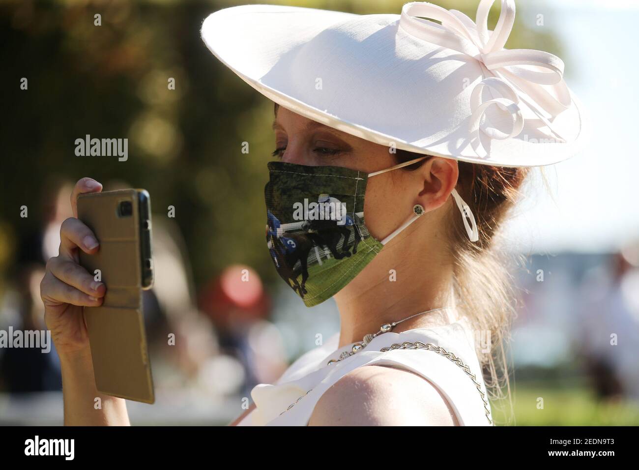 13.09.2020, Iffezheim, Bade-Wurtemberg, Allemagne - mode: Femme élégamment habillée dans un chapeau porte un protecteur de bouche-nez de bricolage et prend des photos avec Banque D'Images