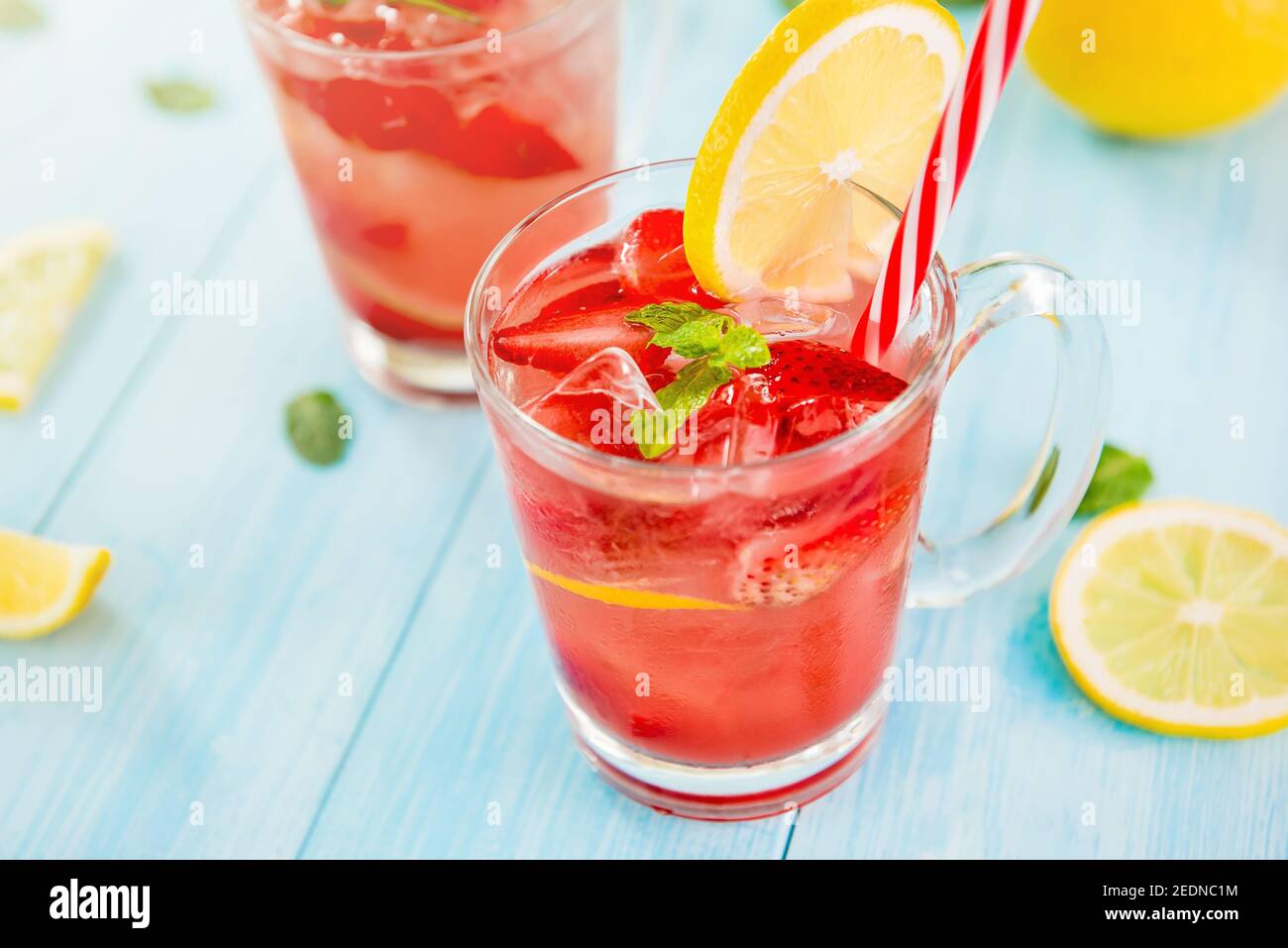 Boissons rafraîchissantes colorées pour l'été, jus de limonade aux fraises doux et aigre avec glaçons dans les verres garnis de citron en tranches Banque D'Images