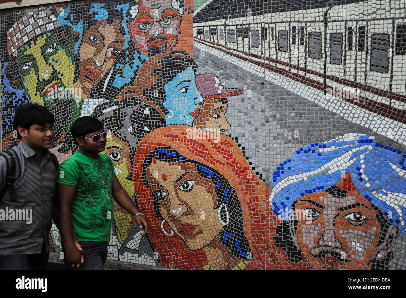 21.02.2011, Kalkutta, Bengale-Occidental, Inde - deux jeunes marchent devant une mosaïque de carreaux colorés en face d'une station de métro. 0SL110221D009CAROEX.JP Banque D'Images