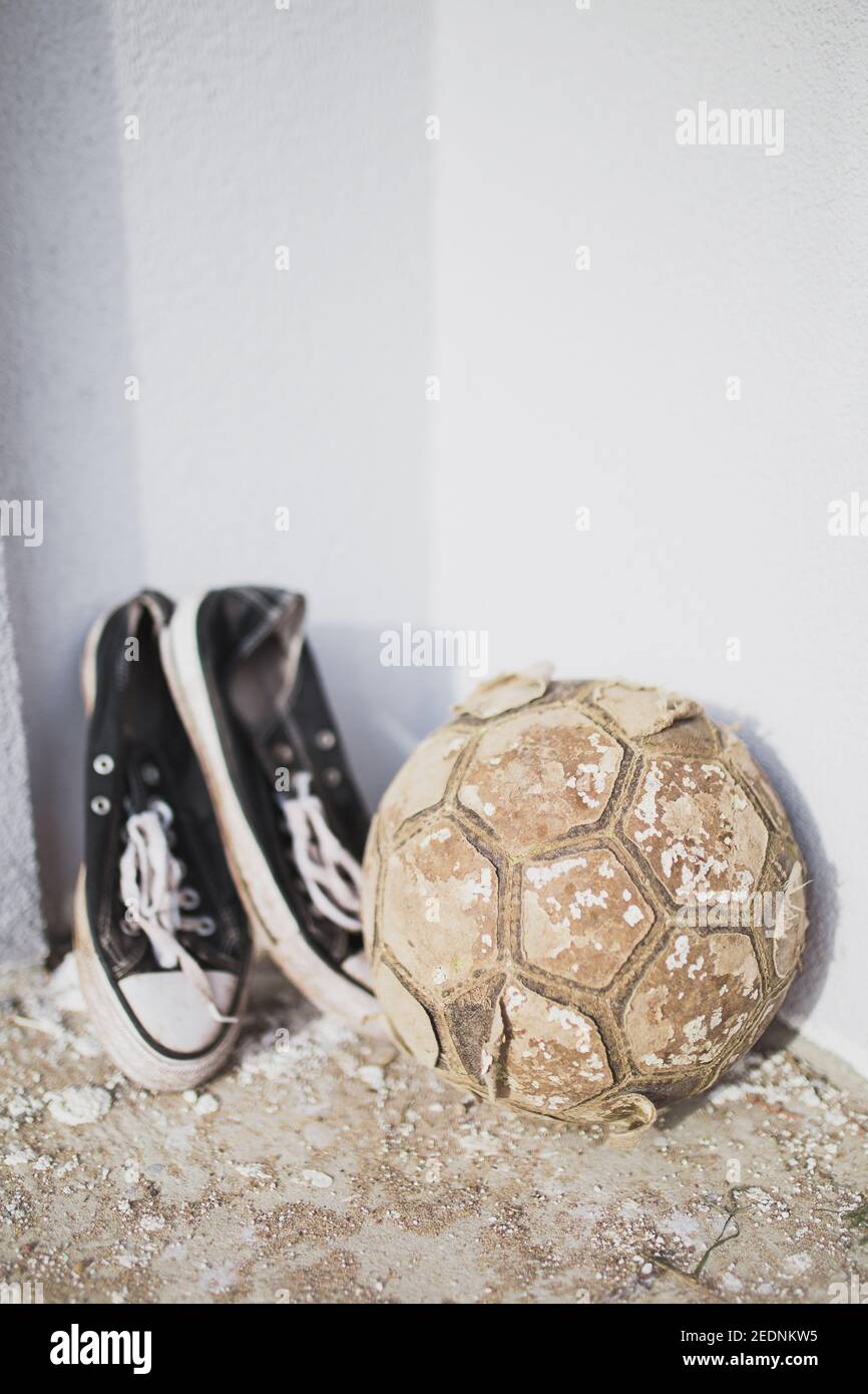 Vintage usé de l'équipement de football - vieux balle en lambeaux et baskets - jeu préféré Banque D'Images