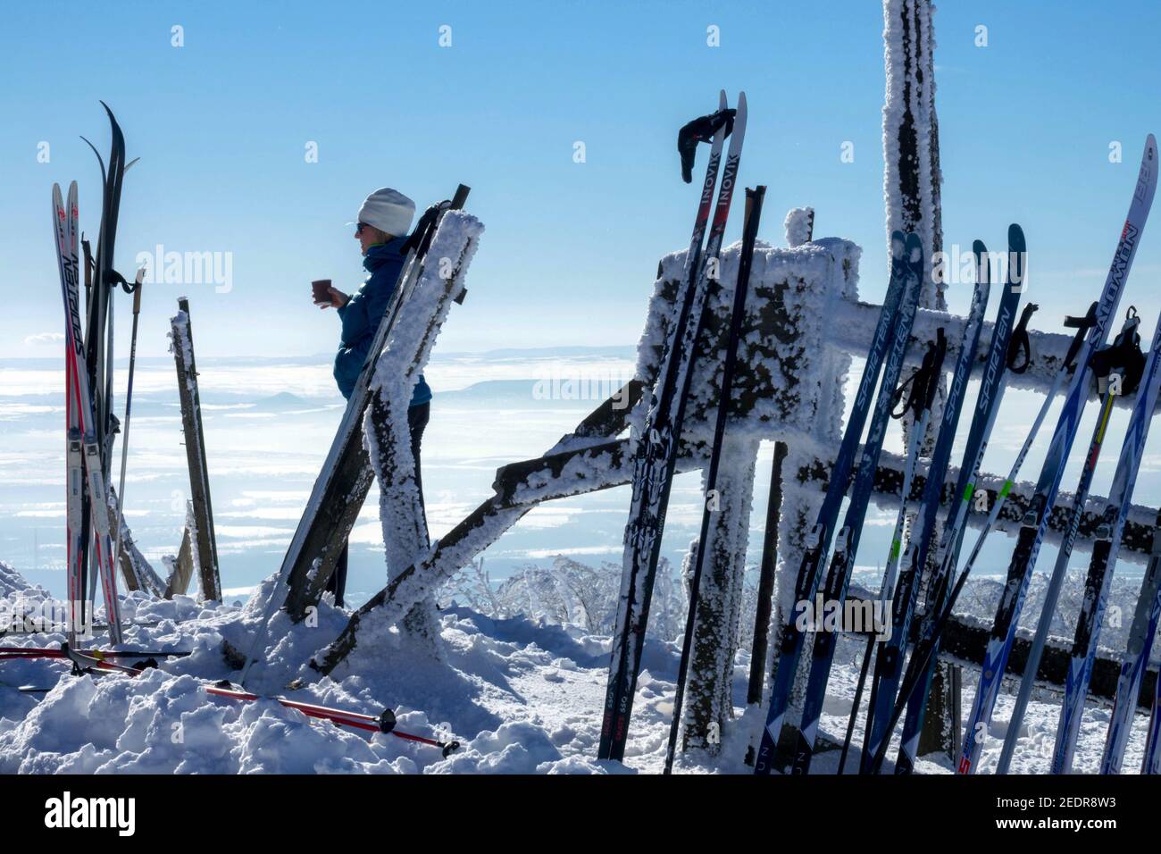 Skis de fond dans un rack et une femme buvant du café dans la vue sur la montagne scène d'hiver Krusne Hory Erzgebirge Ore Mountains République tchèque Banque D'Images