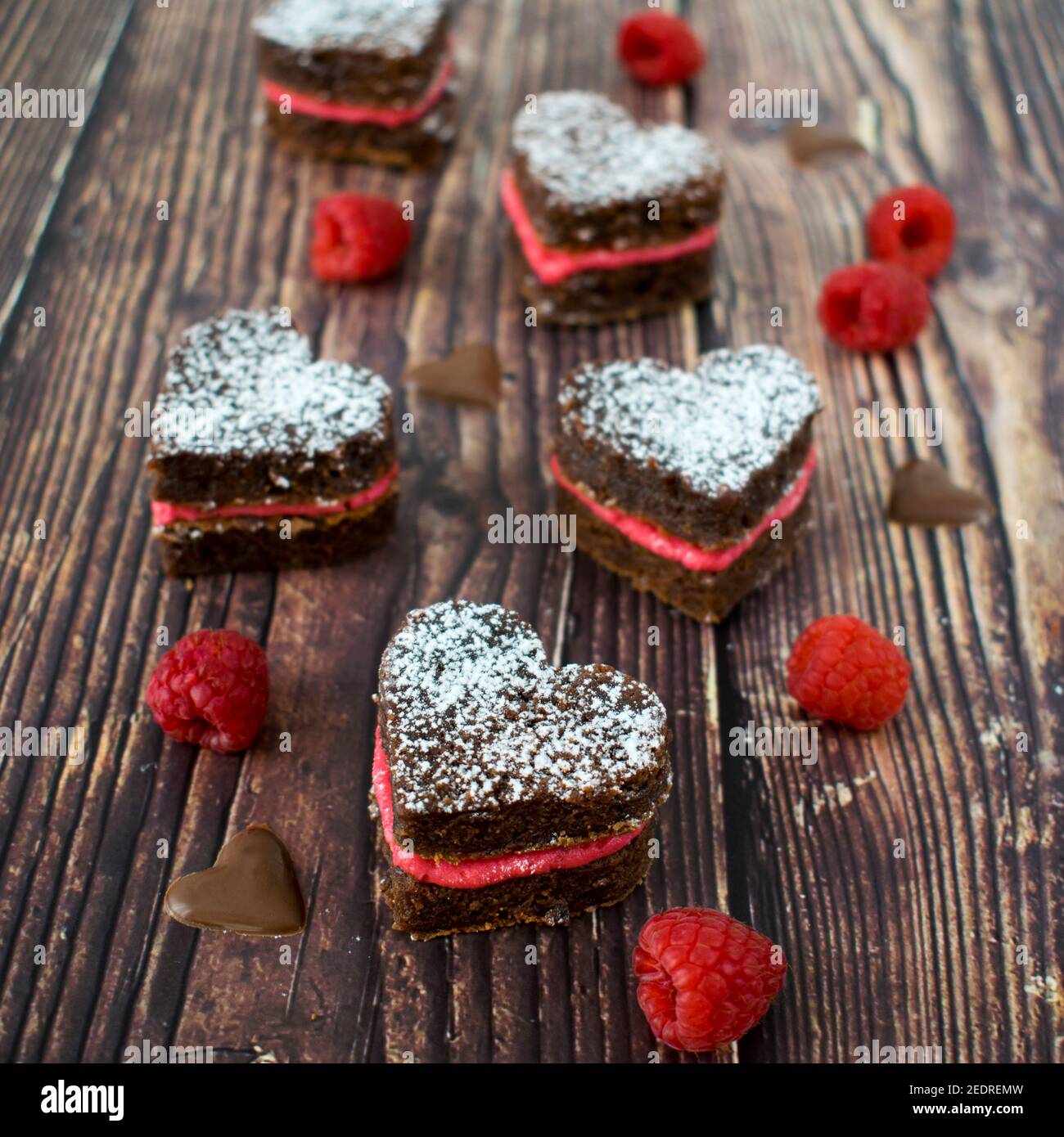 Biscuits au brownie en forme de cœur et crème de framboise fraîche. Banque D'Images