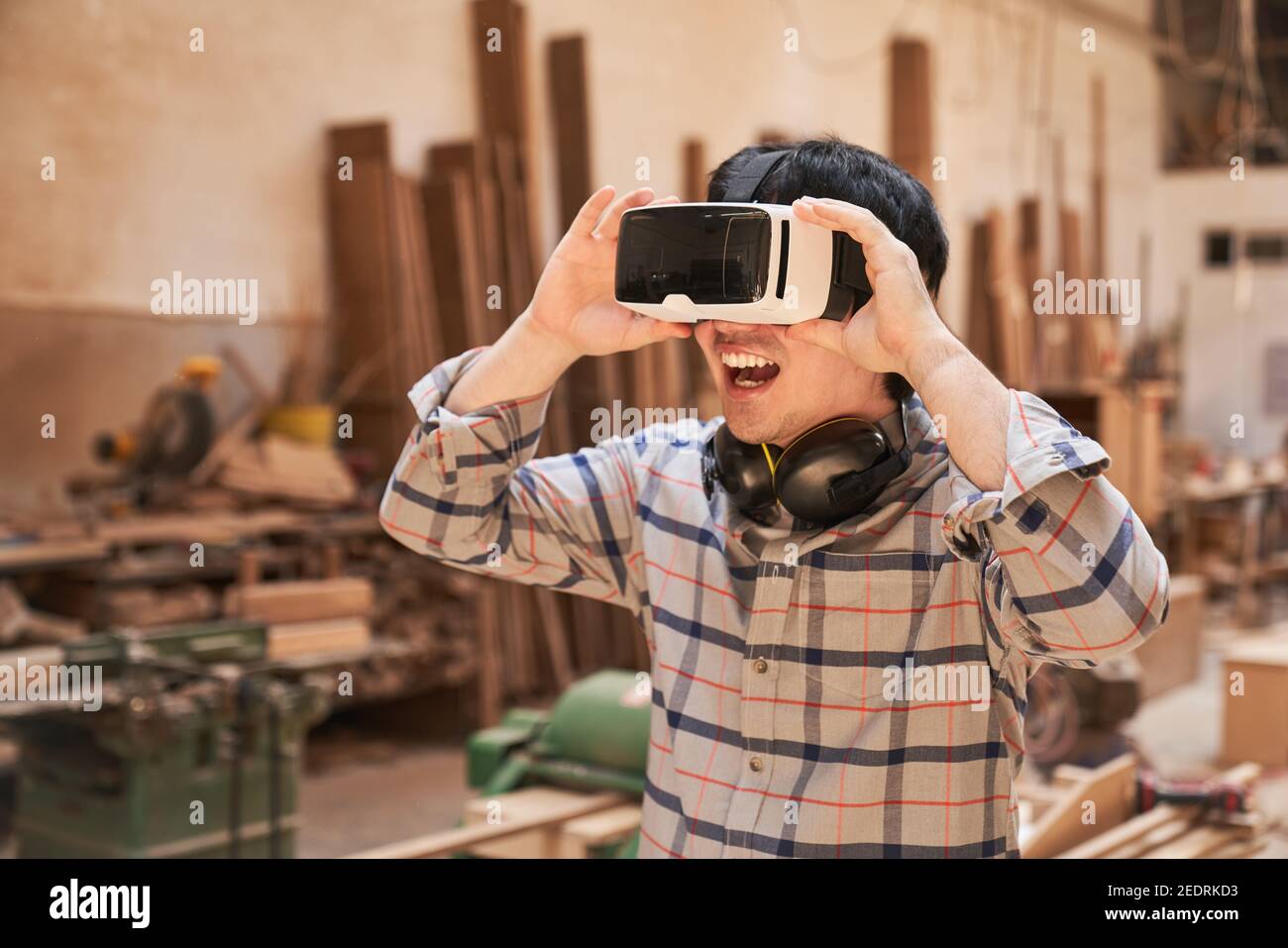 Artisan émerveillé avec des lunettes VR pour simuler la menuiserie de l'avenir Banque D'Images