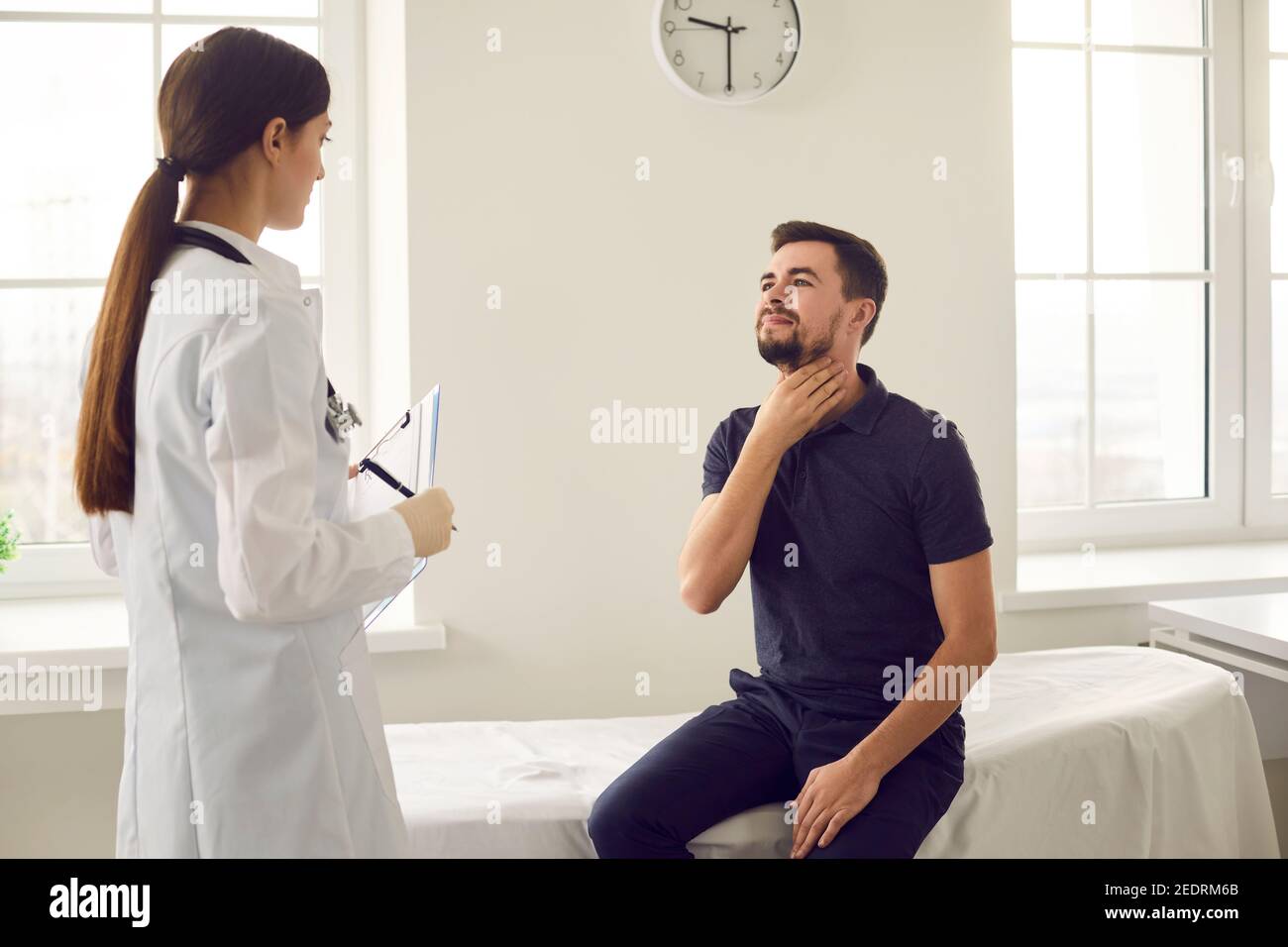 Le patient se plaint auprès du médecin des symptômes de la grippe tels que le mal de gorge et la toux. Banque D'Images