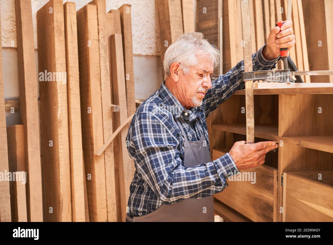 Artisan senior comme menuisier et fabricant d'armoires encollage le armoire Banque D'Images