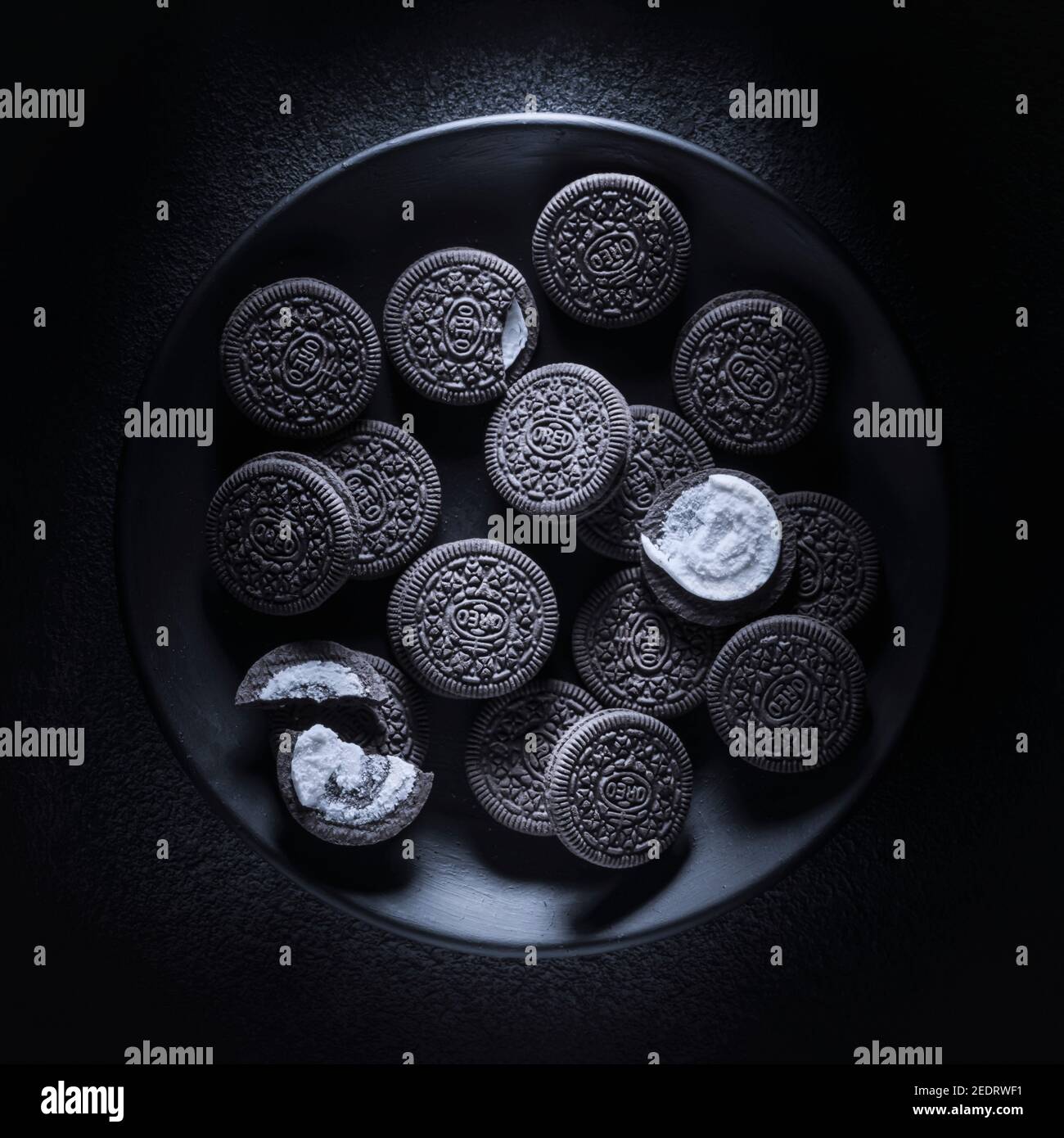 KRASNOYARSK, RUSSIE, 9 février 2020 : biscuits oreiro noirs en gros plan dans une assiette, vue du dessus. Arrière-plan texturé sombre. Banque D'Images