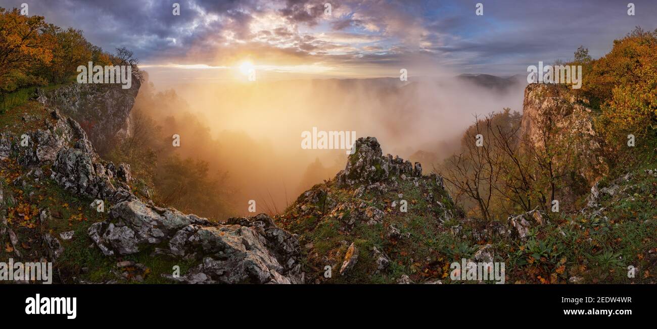 Lever de soleil spectaculaire dans les montagnes avec brouillard, soleil et silhouette de l'homme - panorama paysage Banque D'Images
