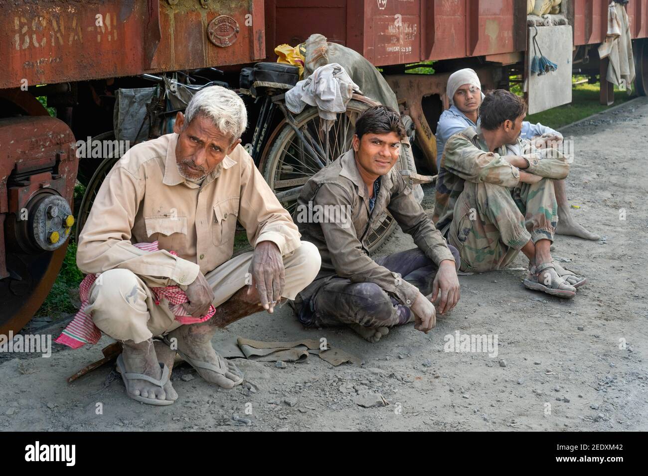 Les travailleurs manuels employés pour déplacer de lourds sacs de ciment profitent d'une pause aux côtés du chemin de fer à Mathura, Uttar Pradesh, Inde. Banque D'Images