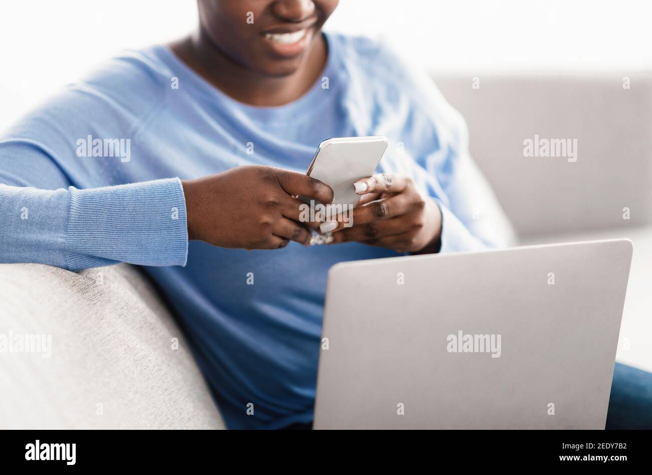 Gros plan d'une femme souriante utilisant un smartphone à la maison Banque D'Images