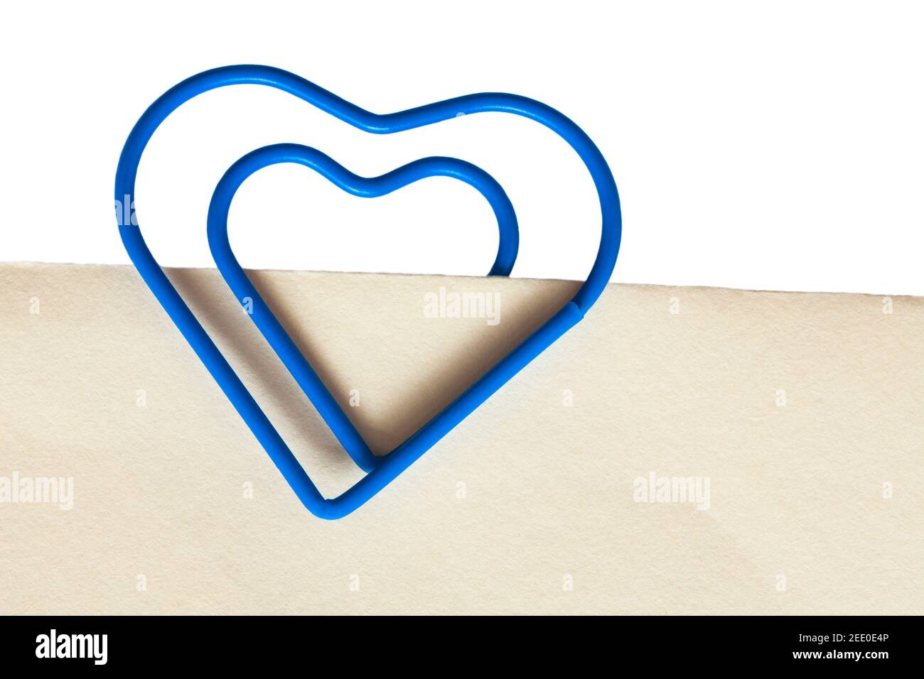 trombone en forme de coeur bleu sur papier blanc crème - conserver  ensemble, rester ensemble concept Photo Stock - Alamy