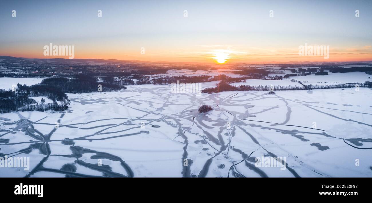 Tir de drone au-dessus du réservoir du barrage à Bautzen au coucher du soleil avec lac gelé hiver saison neige blanche Banque D'Images