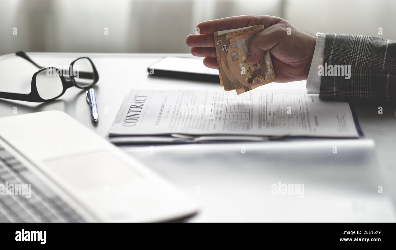 Le concept de corruption, un homme d'affaires tenant de l'argent en main et donnant des pots-de-vin pour avoir signé des faveurs politiques contractuelles Banque D'Images