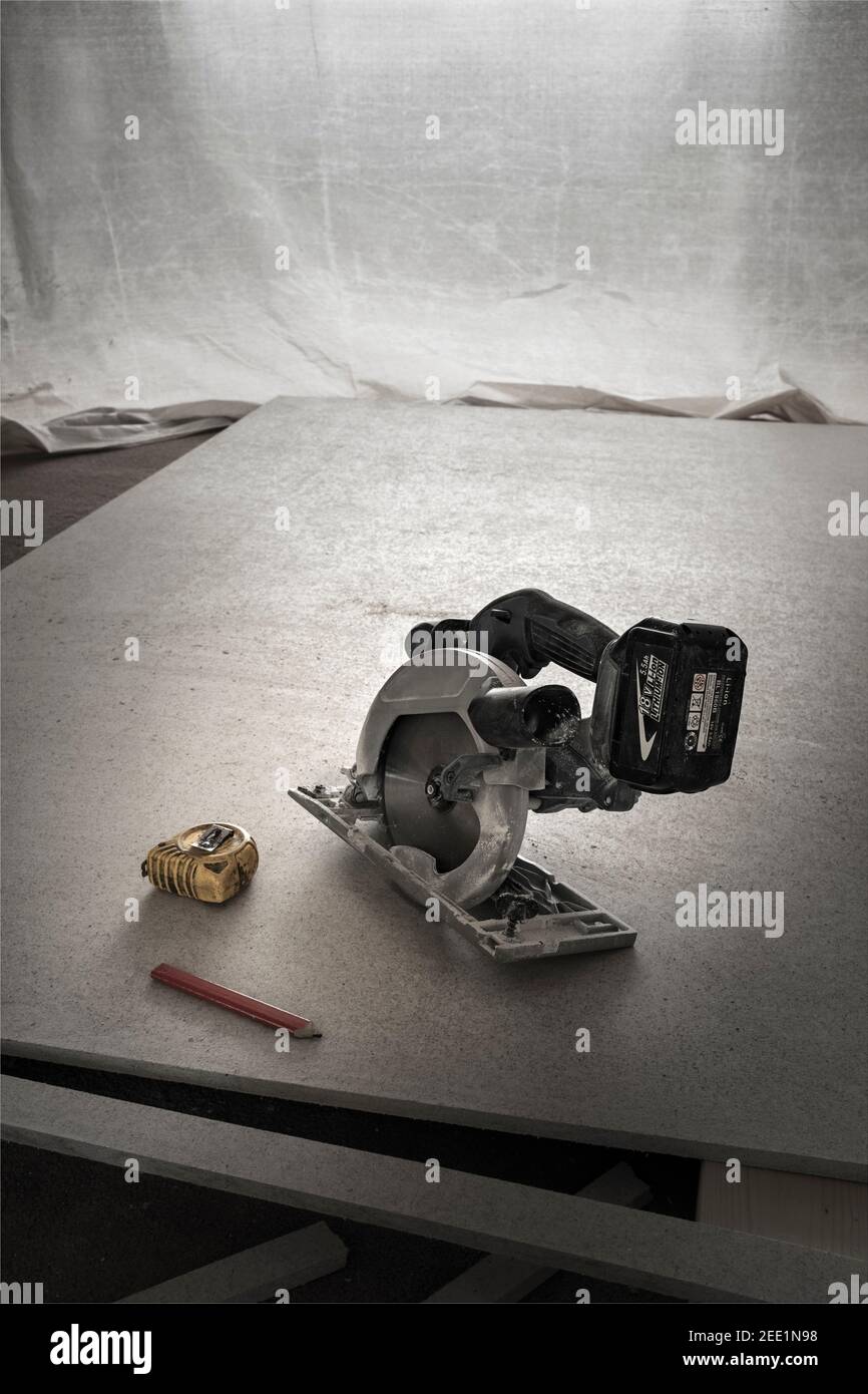 Scie circulaire sans fil et panneau fibreux à base de gypse. Banque D'Images