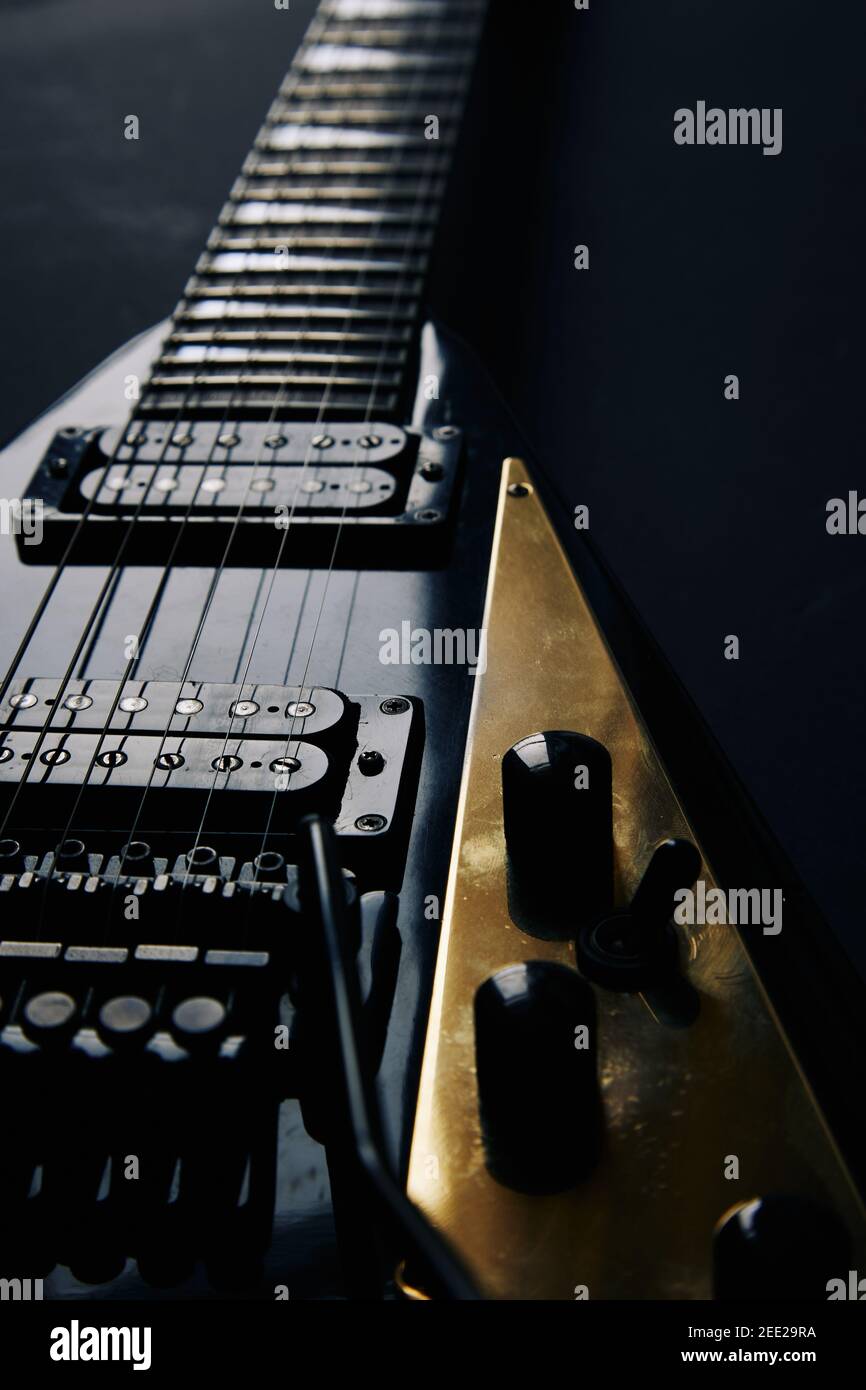 Rogner le cliché de mise au point douce de guitare électrique en forme de V noir sur fond de grunge foncé Banque D'Images