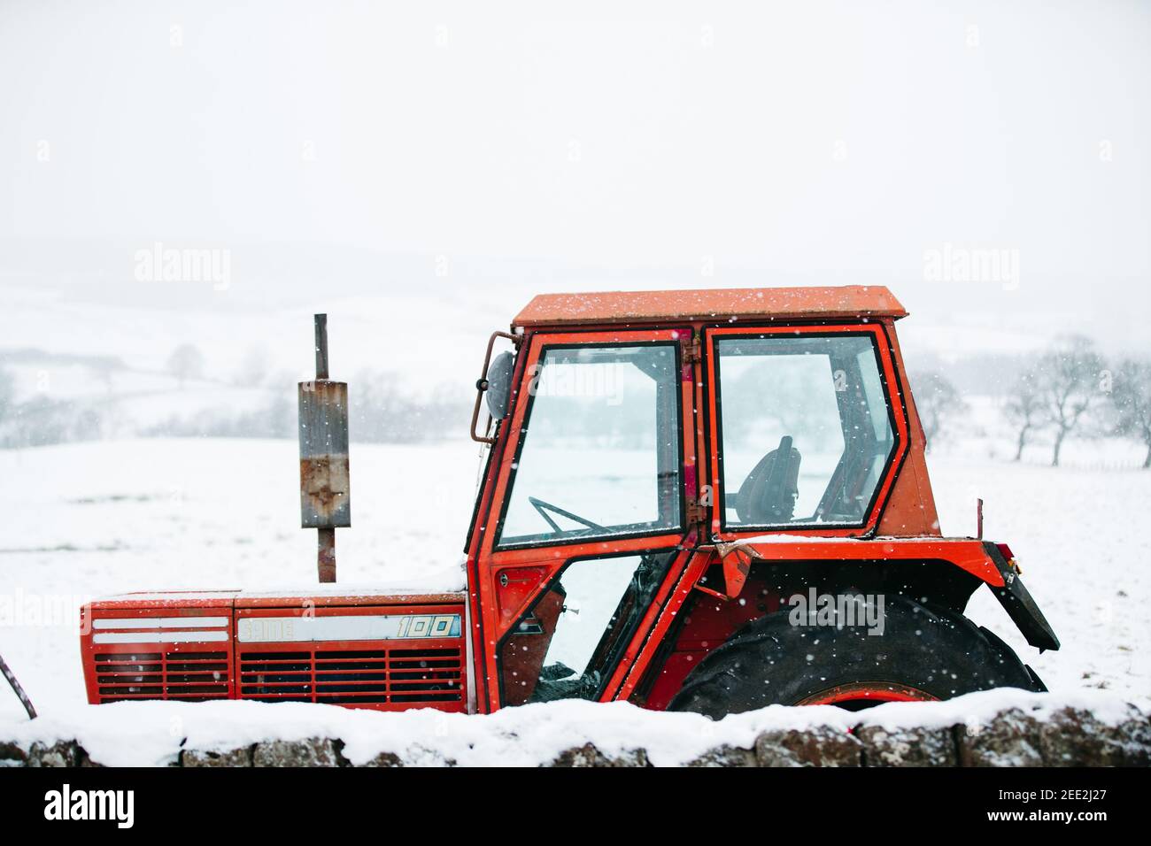 Tracteur rouge dans la neige, Fintry, Écosse. Banque D'Images