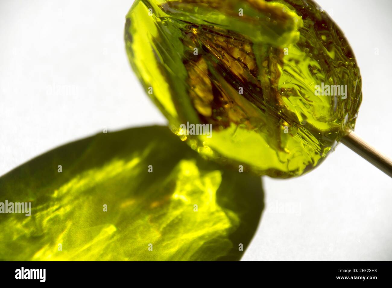 Lollipop jaune avec une tranche de citron à l'intérieur sur fond blanc. Banque D'Images