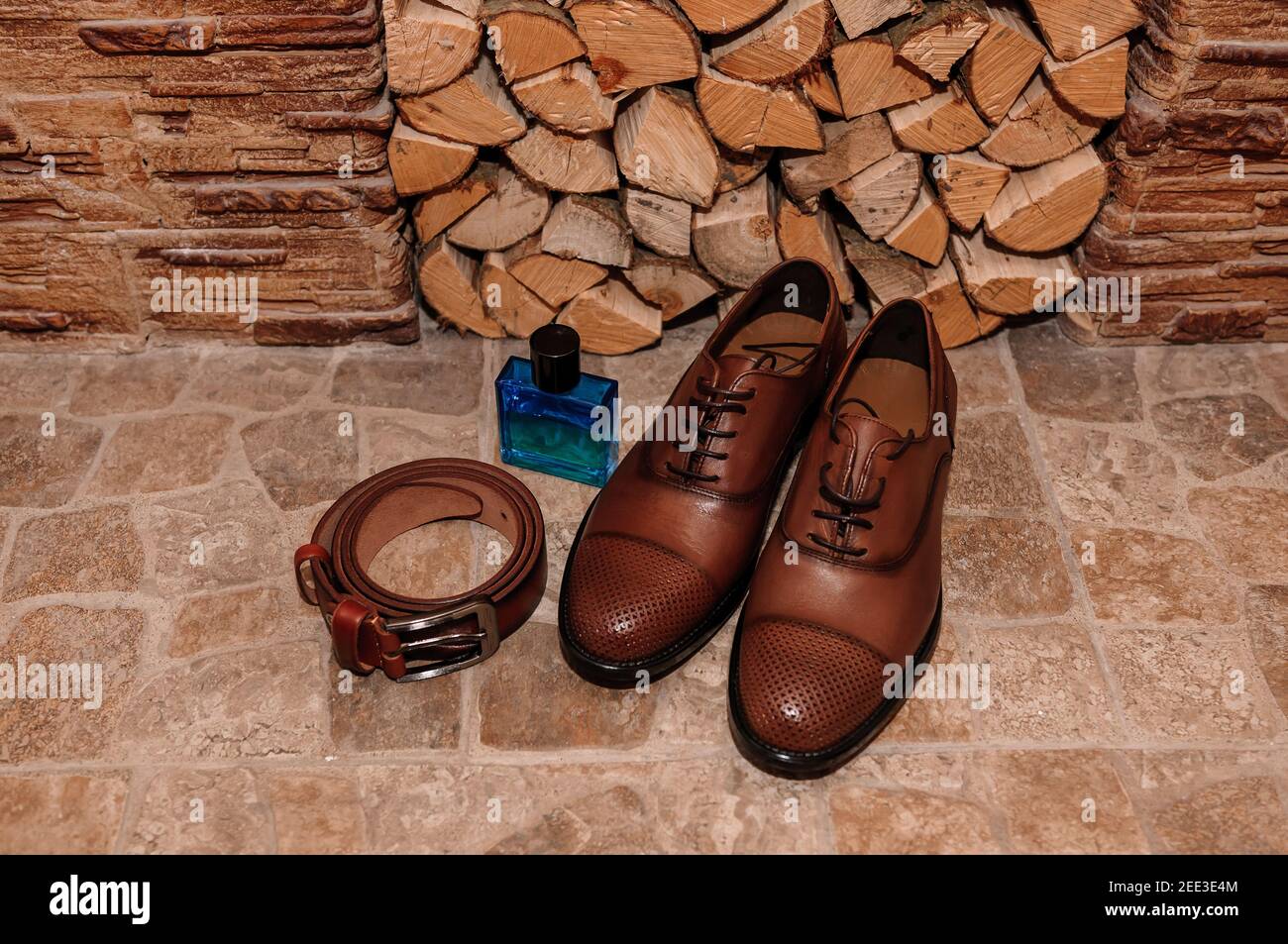 Chaussures brunes pour hommes. Ceinture. Parfum. Anneaux de mariage. Accessoires pour marié Banque D'Images