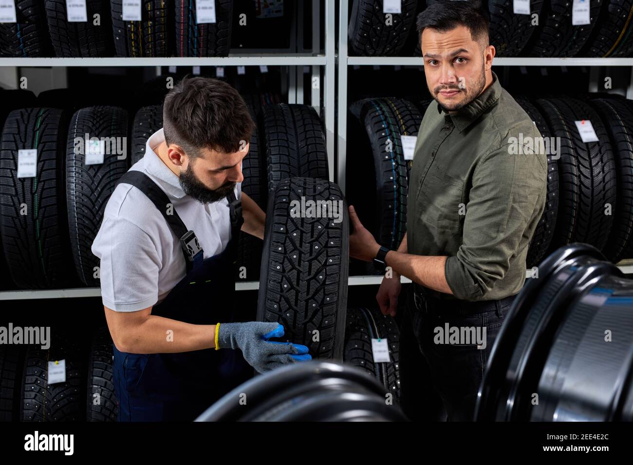 le vendeur de pneus parle des caractéristiques du produit au client nous  sommes venus examiner l'assortiment représenté dans l'atelier de service  automobile Photo Stock - Alamy