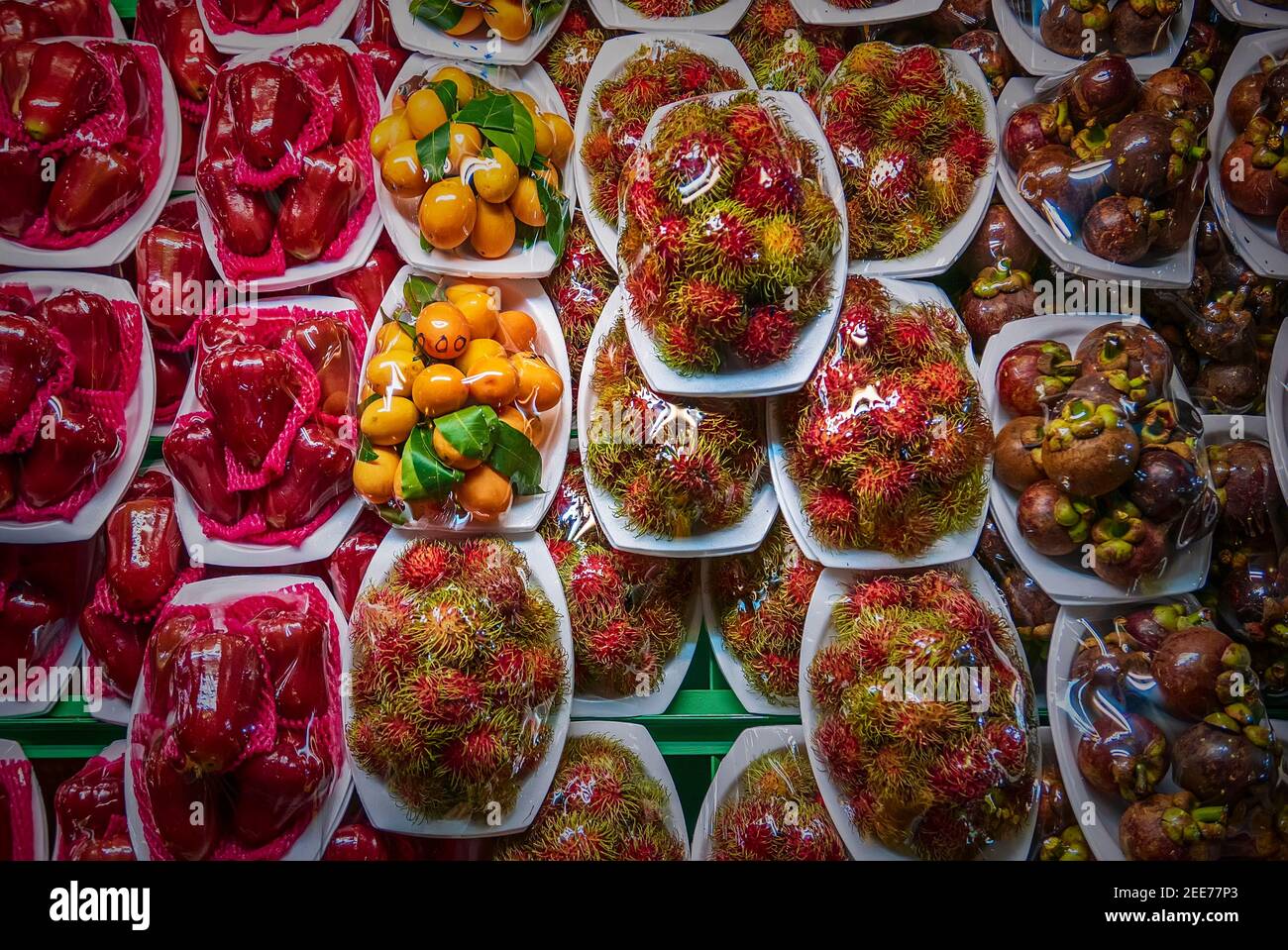 Marché aux fruits de rue en Thaïlande avec divers fruits exotiques frais: Mangousteen, rambutan, pomme rose dans des emballages en plastique Banque D'Images
