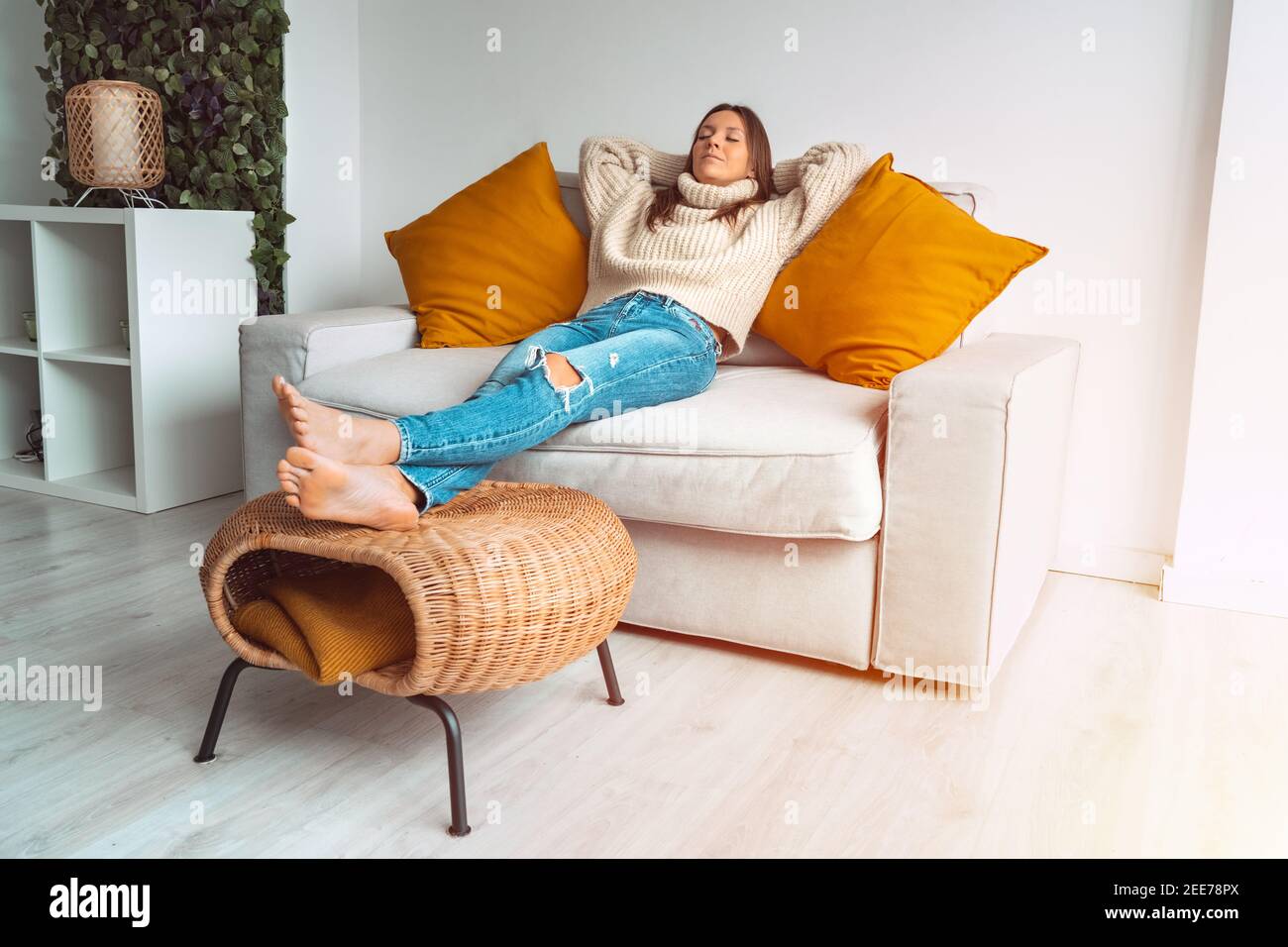 Femme calme et détendue se reposant ou dormant sur le canapé à la maison. Pause Banque D'Images