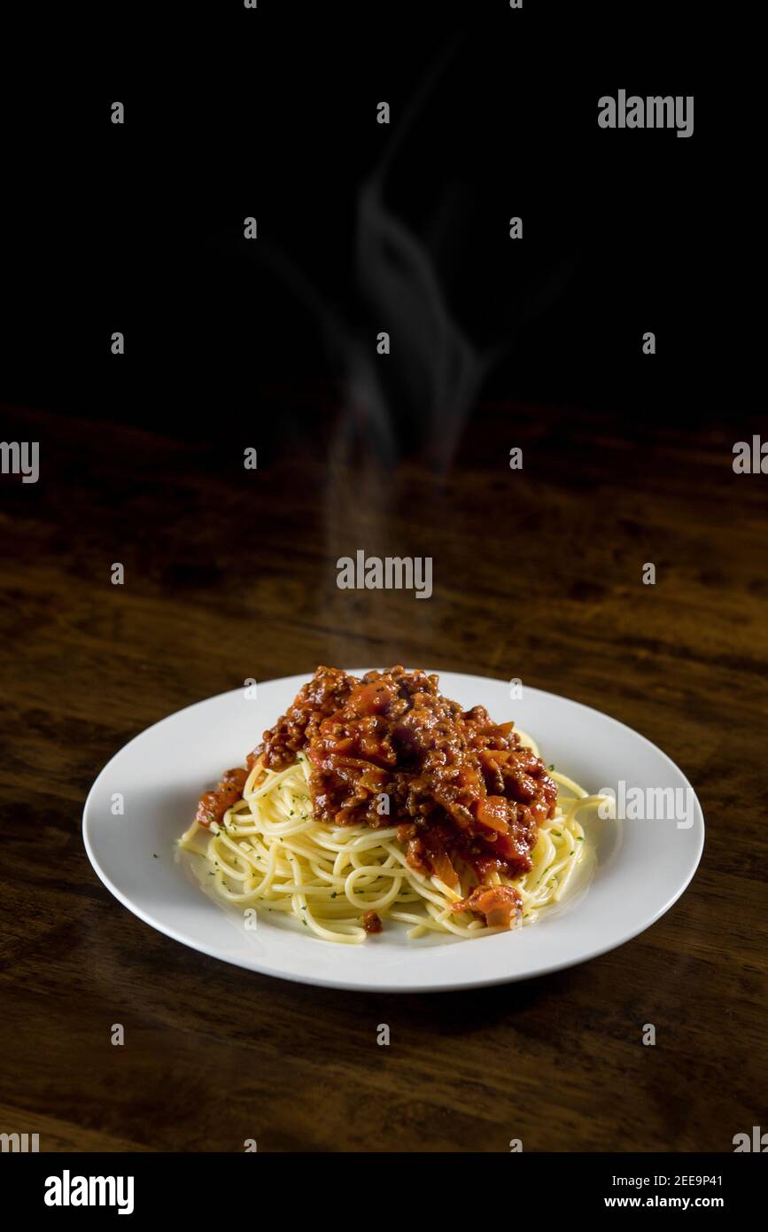 Délicieux spaghetti italiens faits maison avec sauce à la viande bolognaise chaude plaque blanche à la table Banque D'Images