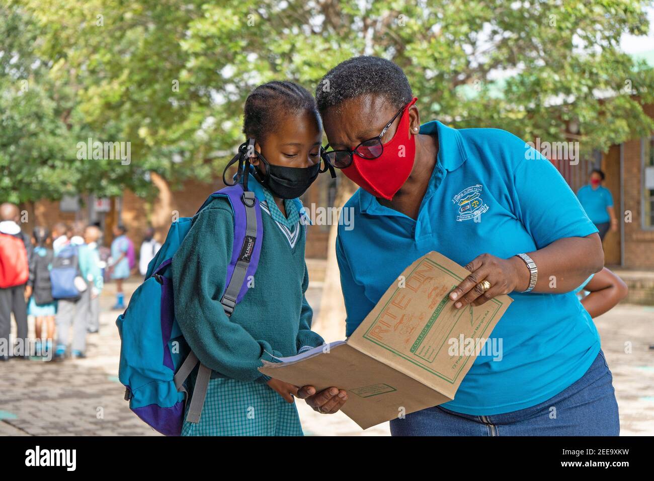 Johannesburg, Afrique du Sud. 15 février 2021. Un enseignant vérifie l'information d'un étudiant dans une école primaire de Johannesburg, Afrique du Sud, 15 février 2021. Plus de 20,000 écoles publiques en Afrique du Sud ont été rouvertes, lundi, conformément au strict respect du protocole COVID-19. Credit: Matthew Martin Brink/Xinhua/Alay Live News Banque D'Images