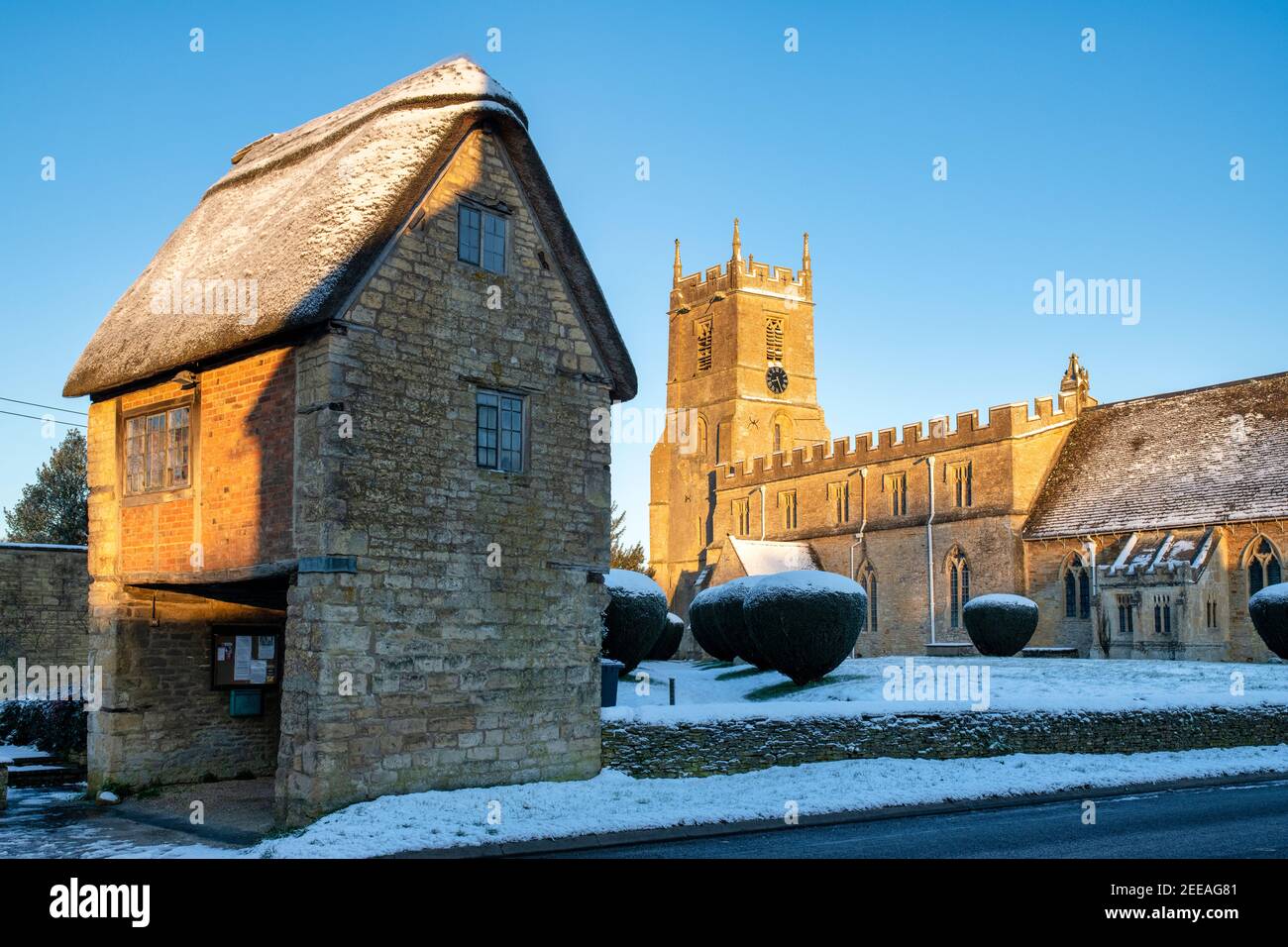 Église Saint-Pierre et Saint-Paul et porte Lych dans la neige de janvier juste après le lever du soleil. Long Compton, Warwickshire, Angleterre Banque D'Images