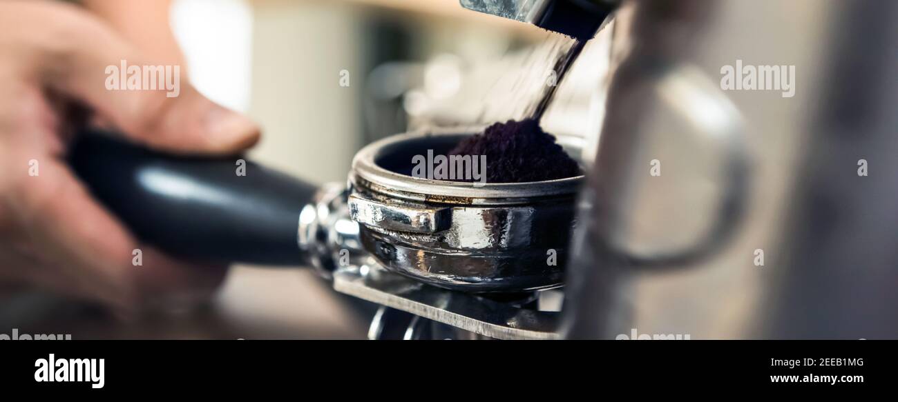 Machine à moulin automatique pour moudre les grains de café dans le panier porte-filtre Banque D'Images