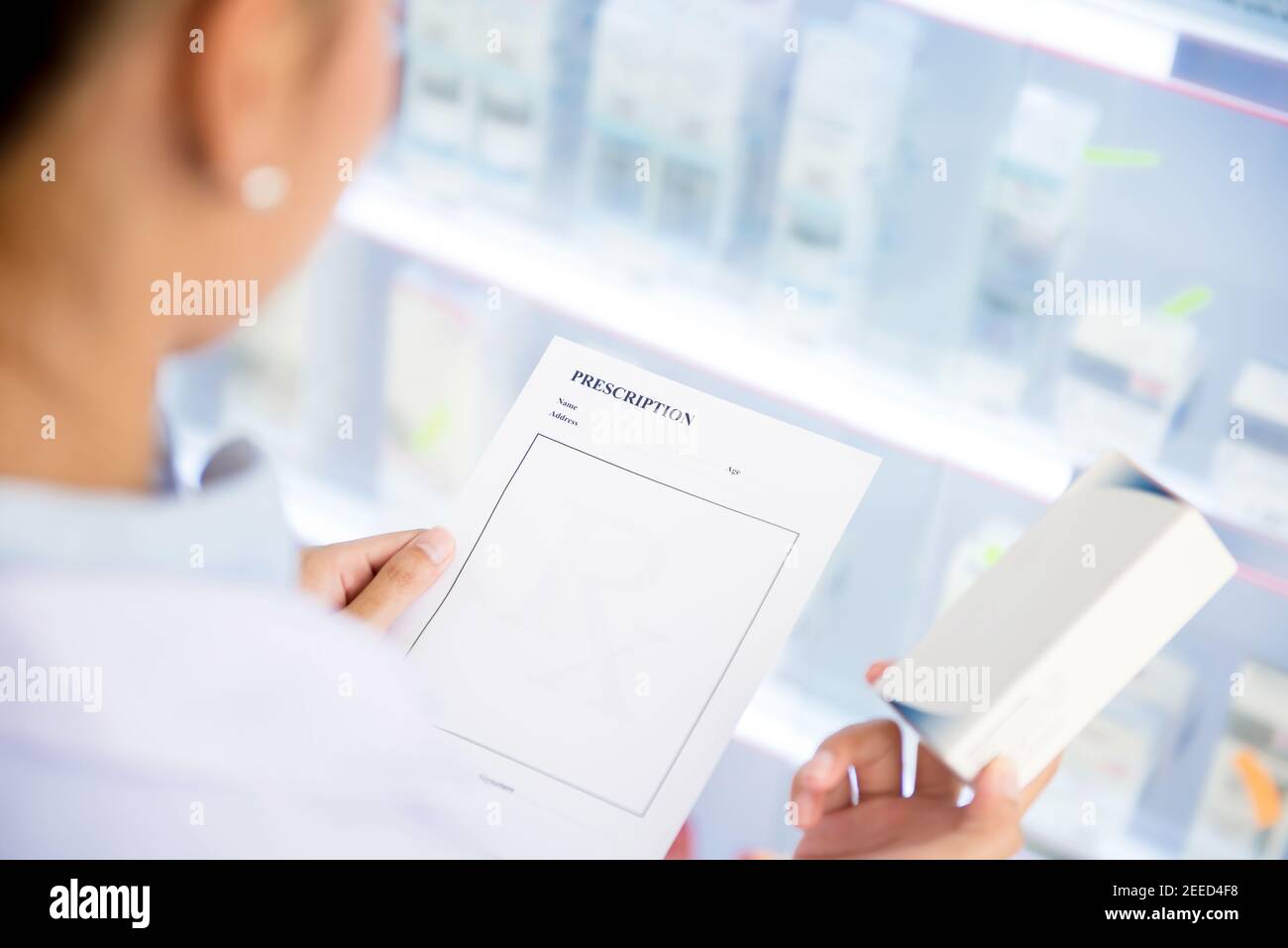 Une femme médecin ou pharmacien qui tient le papier d'ordonnance Rx pour vérifier le médicament en pharmacie (ou en pharmacie) Banque D'Images