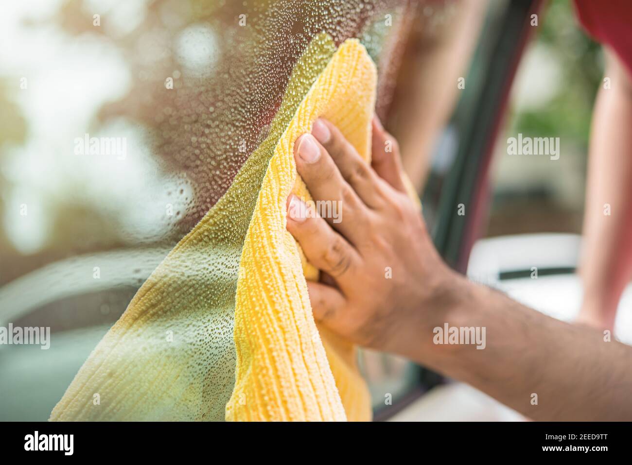 Le personnel du service entretien automobile nettoie les vitres de la voiture avec de la microfibre tissu Banque D'Images
