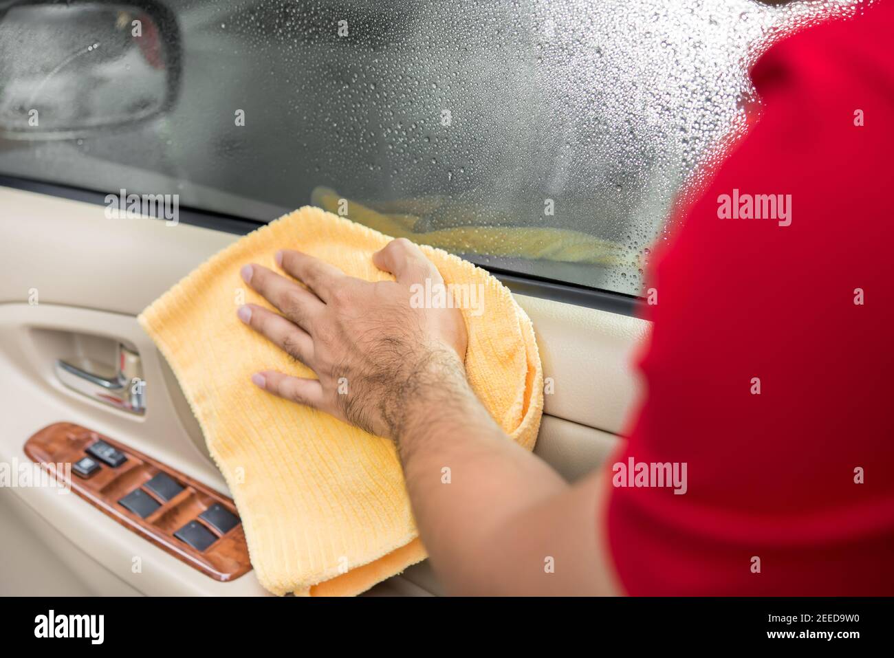 Le personnel d'entretien de l'auto nettoie le panneau intérieur de la porte de voiture avec tissu en microfibre Banque D'Images