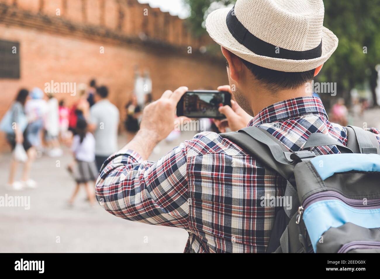 Un routard de tourisme asiatique prenant des photos avec un smartphone à la porte de Tha Phae, l'un des plus célèbres monuments de la ville de Chiang Mai en Thaïlande Banque D'Images