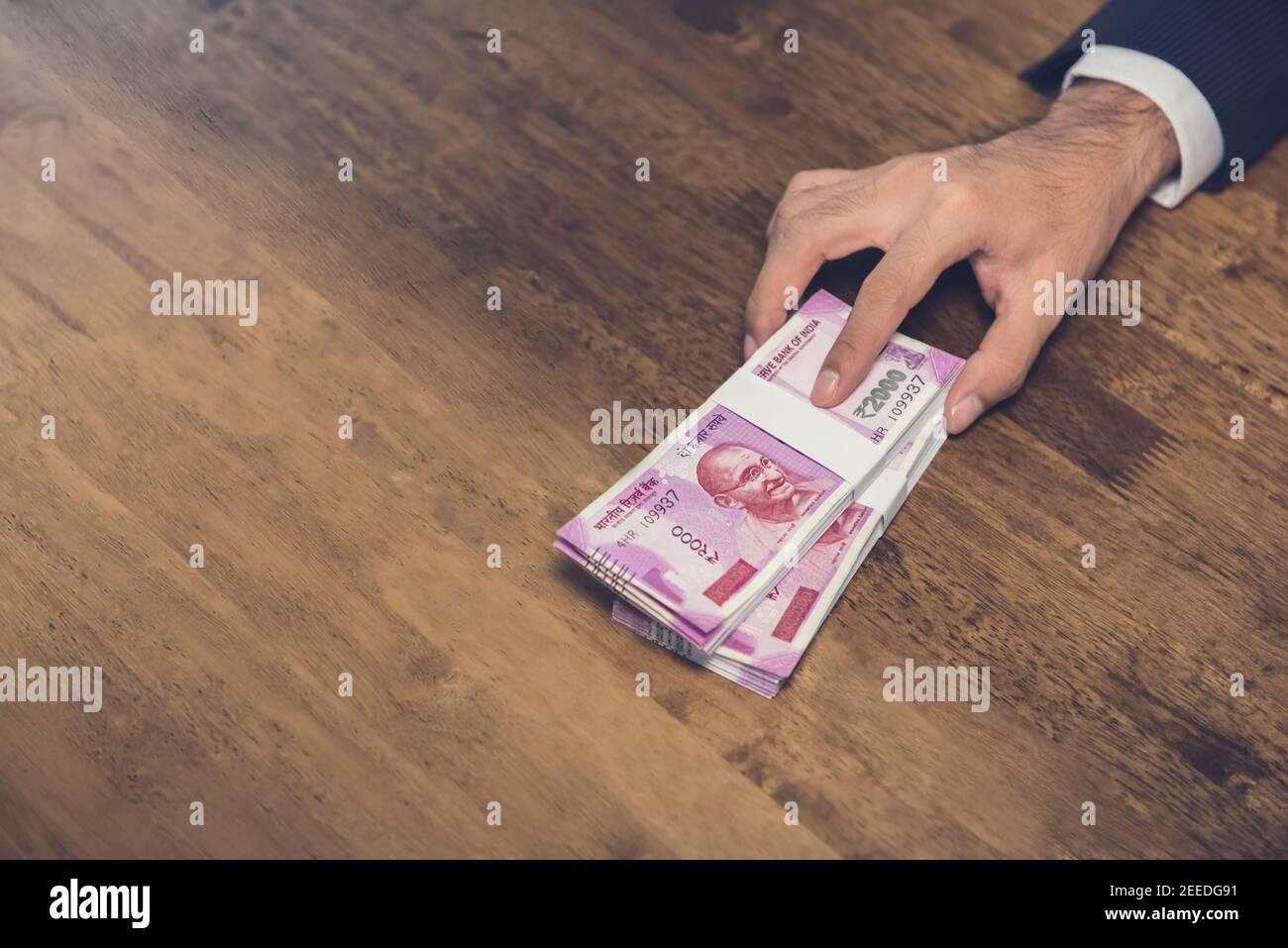 Homme d'affaires donnant (offrant) pile d'argent, monnaie de roupie indienne, sur la table - prêt, corruption et concept de corruption Banque D'Images