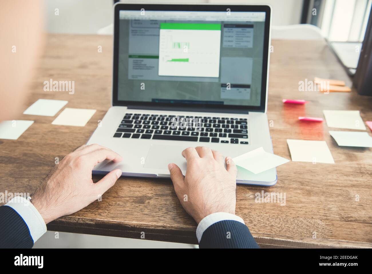 Homme d'affaires utilisant un ordinateur portable analysant des données financières sur le bureau Banque D'Images