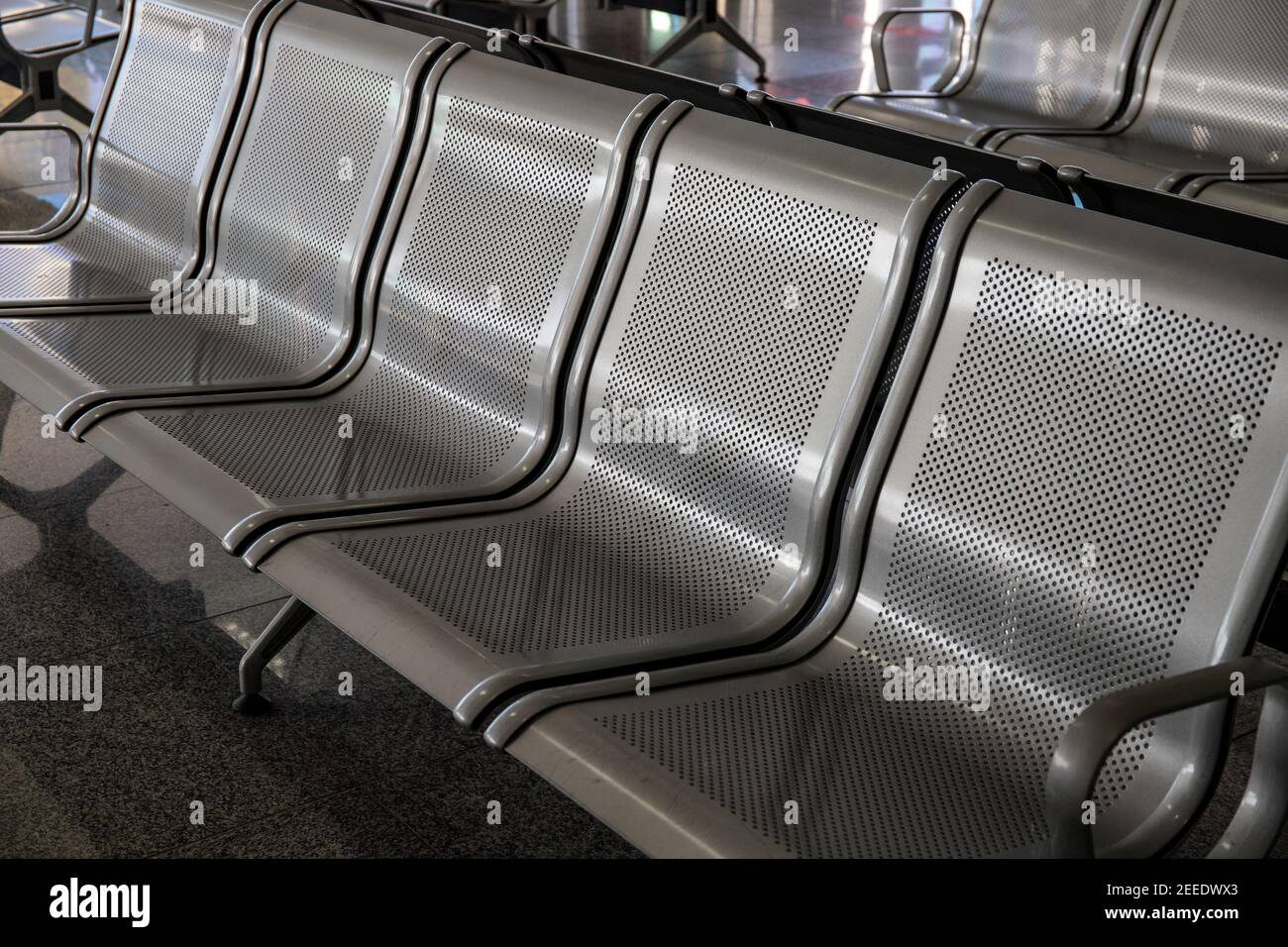 Rangée de chaises en métal pour les clients d'aéroport. Un atout moderne pour les lieux publics. Concept d'attente dans l'aéroport. Mobilier métallique perforé. Être inconfortable Banque D'Images