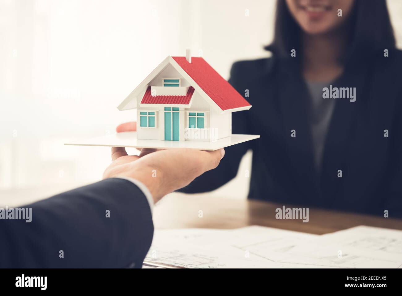 Agent immobilier ou architecte présentant le modèle de maison au client Banque D'Images