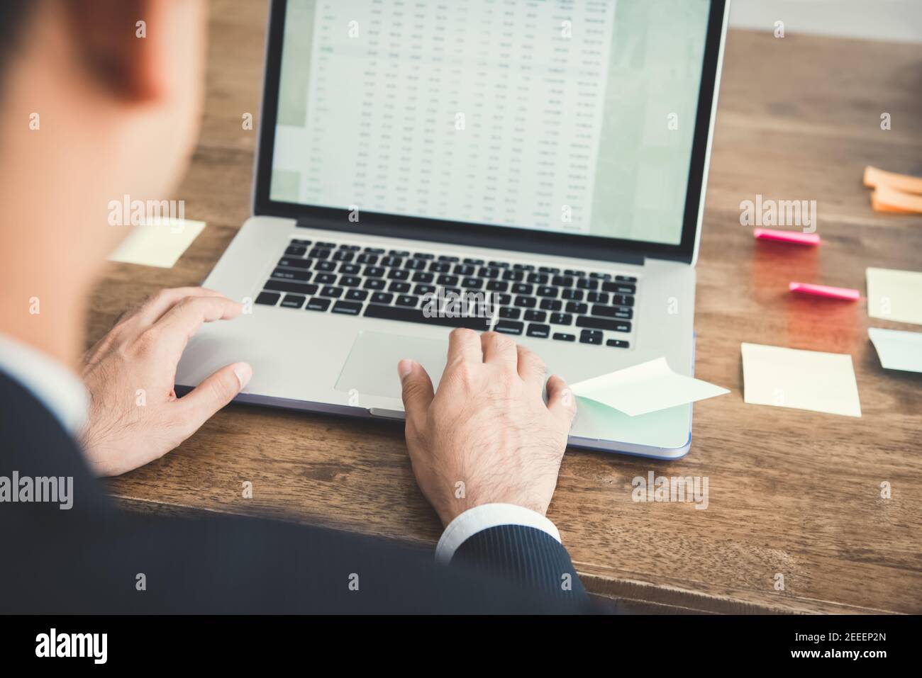 Homme d'affaires se concentrant sur l'utilisation d'un ordinateur portable, l'analyse des données à l'écran - vue sur l'épaule Banque D'Images
